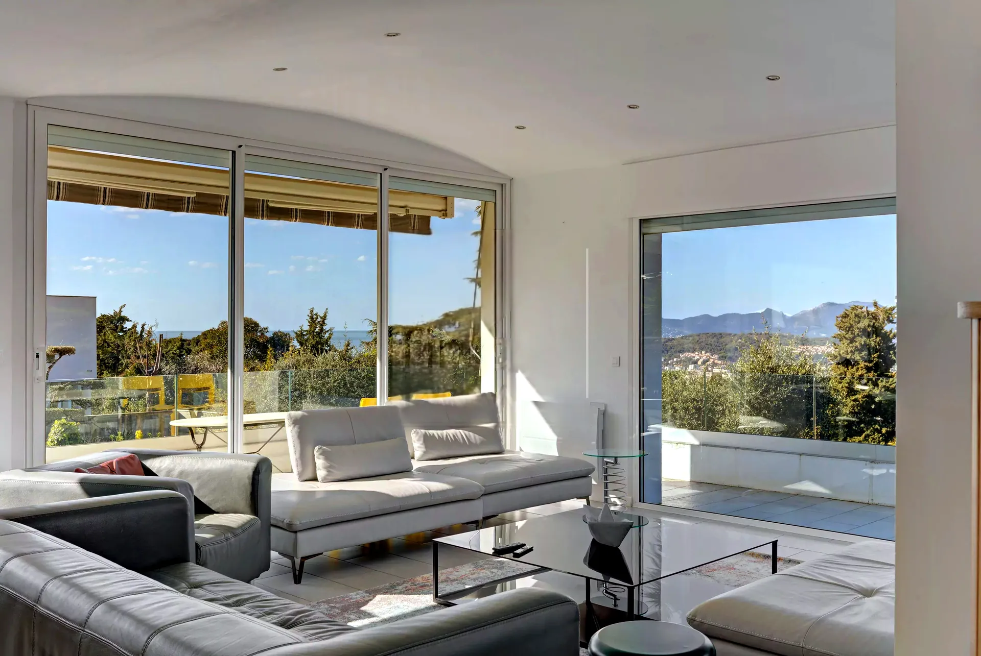 Grand salon de la villa ouvert sur la terrasse et la vue mer